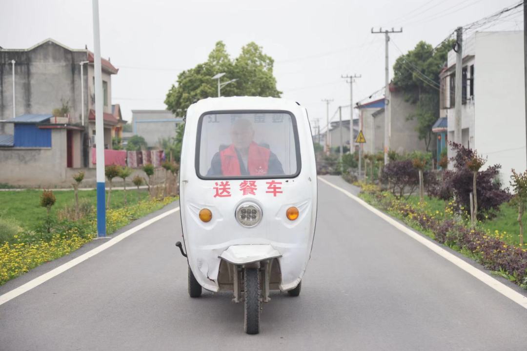 楊永東騎著“送餐車”，行駛在道路上。.jpeg