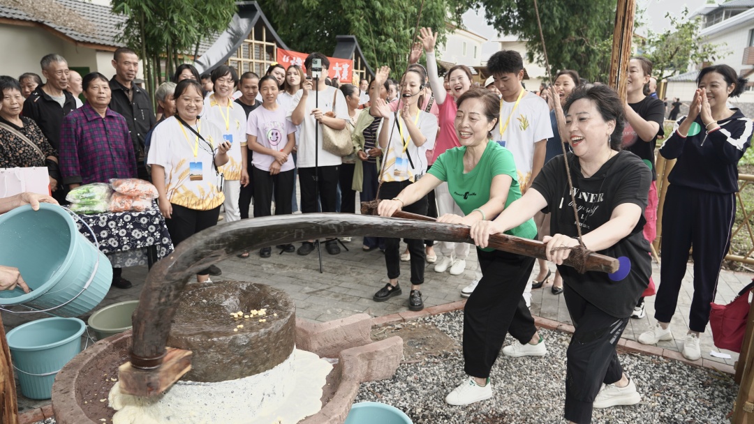 9月22日，在2023年青神縣中國(guó)農(nóng)民豐收節(jié)上，游客體驗(yàn)推石磨等農(nóng)事活動(dòng)。.jpeg