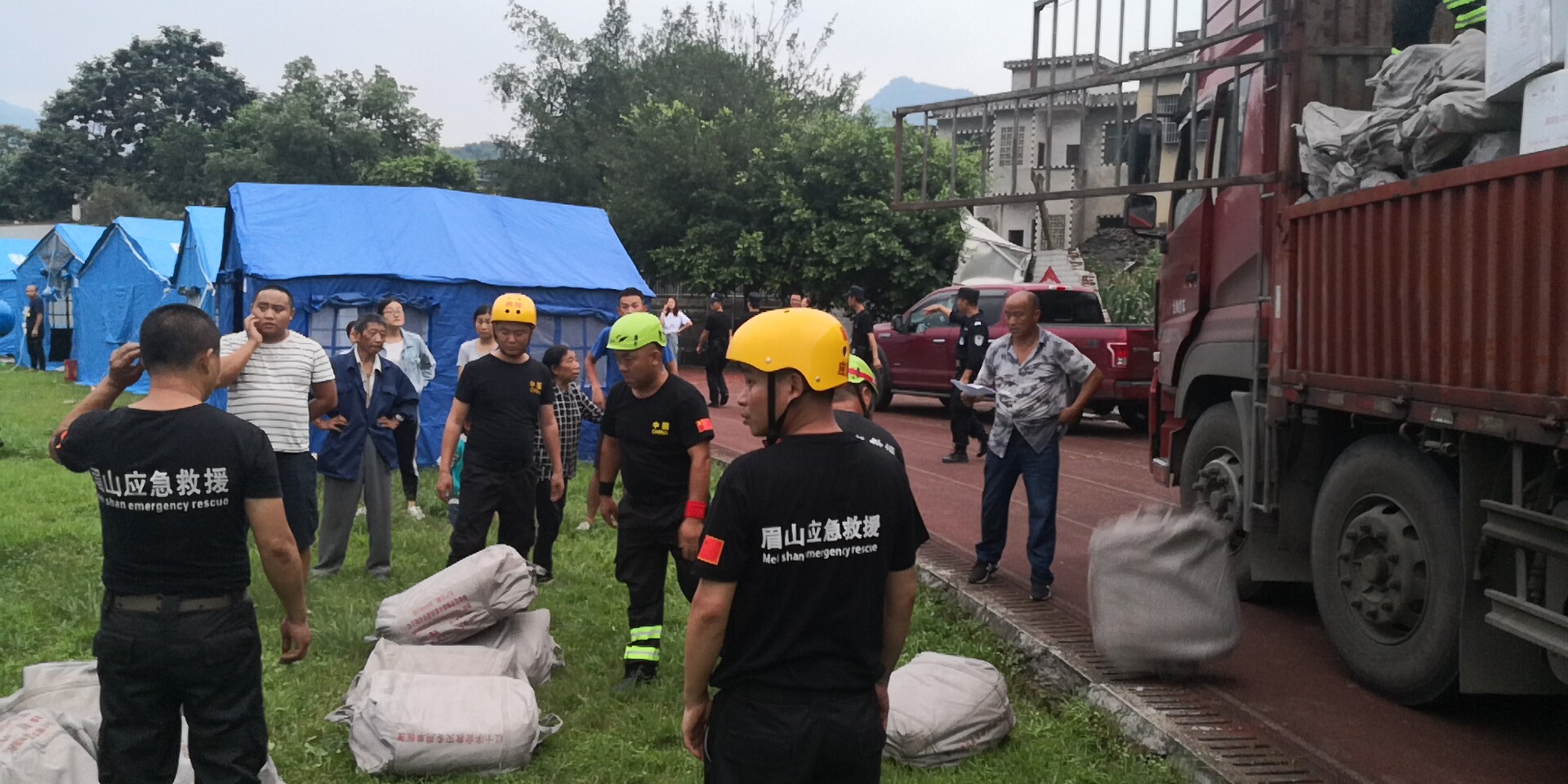 18日晚7時20分左右，救援隊員和武警官兵冒雨為群眾搬運救災帳篷。7.jpg