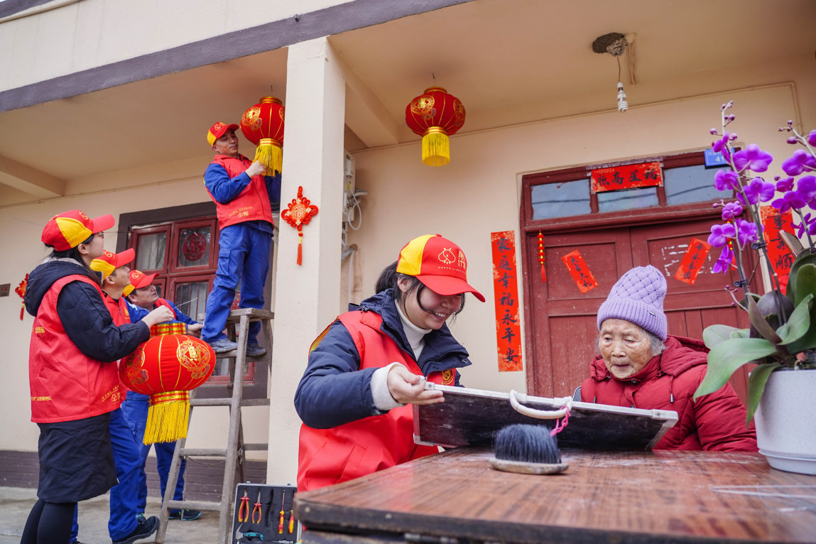 開展新時(shí)代文明實(shí)踐活動(dòng)，志愿者為老人貼對聯(lián)