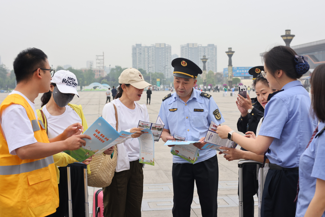 工作人員在眉山東站外向旅客宣傳愛護鐵路相關知識.JPG